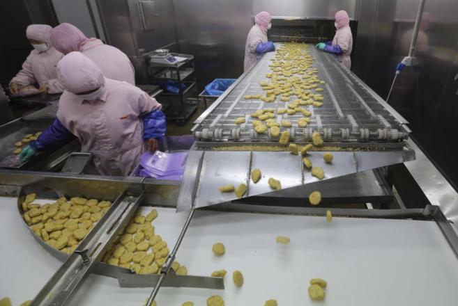 Trabajadores en el interior de la planta clausurada de Husi, en Shanghai. REUTERS