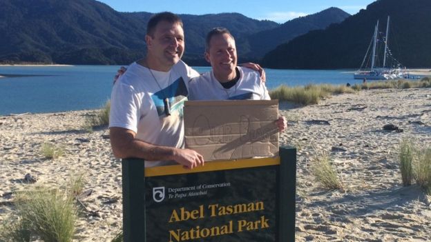 Los impulsores de la campaña Duane Major (izq) y Adam Gardner celebraron que llegaron al objetivo de la compra con un cartel que decía 