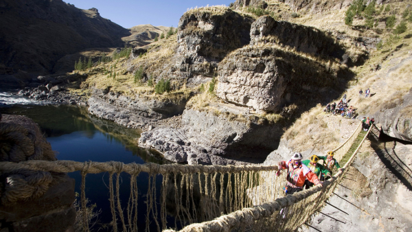 Hombres andinos cruzan el puente colgante de Qeswachaka sobre el río Apurimac, en la provincia sureña de Canas en Cuzco el 12 de junio de 2010 