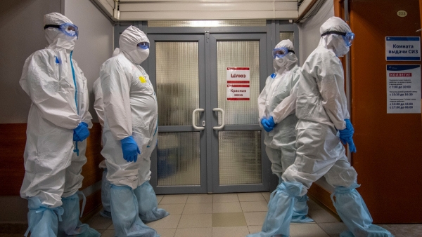 Médicos en trajes protectores esperan fuera de la zona de pacientes con covid-19 en un hospital de Moscú.