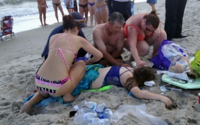 Varios bañistas atienden a una de las víctimas