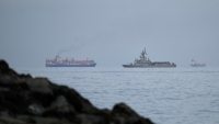Buque de la Armada de Emiratos Árabes Unidos navega junto a un buque de carga en el estrecho de Ormuz, el 11 de marzo de 2026.