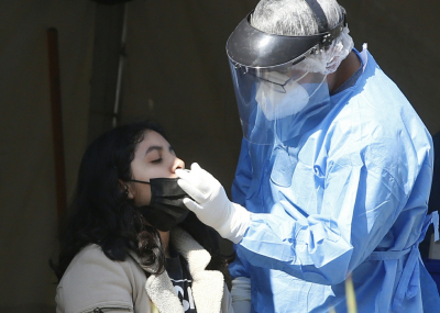 rsonal de salud aplica una prueba de covid-19 a una mujer en un macroquiosco de la CDMX.