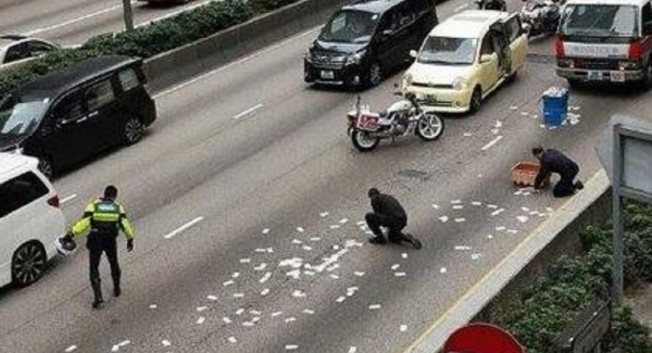 Unas cajas con dinero caídas a la carretera desde un furgón causan atascos en Hong Kong