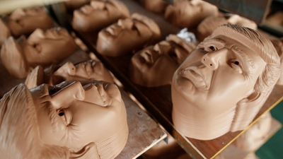 Caretas con la efigie del presidente electo Donald Trump se secan en una fábrica de la provincia china de Zhejian