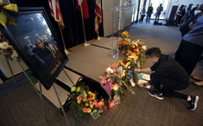 Un estudiante de la Universidad Estatal de California en Long Beach coloca flores durante un tributo a Nohemí González.