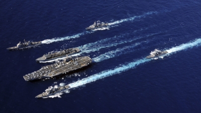 Buques del grupo de ataque del portaaviones Abraham Lincoln, de Estados Unidos, navegan en formación durante un reabastecimiento en marcha mediante el buque de apoyo de combate rápido USNS Rainier, 19 de septiembre de 2010.