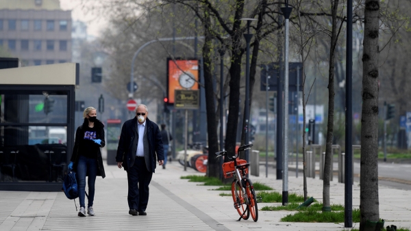 Dos personas con mascarilla en una calle de Milán (Lombardía, Italia), el 20 de marzo de 2020. 