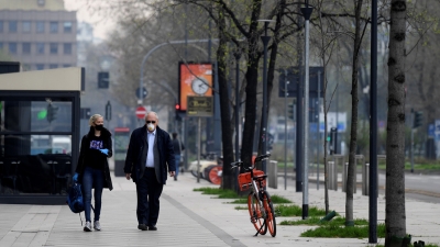 Dos personas con mascarilla en una calle de Milán (Lombardía, Italia), el 20 de marzo de 2020. 