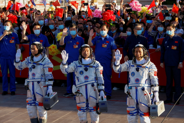 Los taikonautas chinos Tang Hongbo, Nie Haisheng y Liu Boming saludan antes del lanzamiento del cohete Long March-2F Y12, que transporta la nave espacial Shenzhou-12, China, 17 de junio de 2021. 