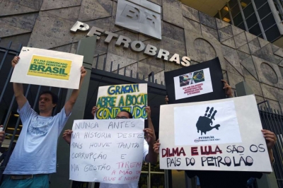 Activistas portan pancartas de protesta frente a las oficinas en Río de Janeiro del gigante petrolero
