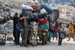 Palestinos transportan sus pertenencias en un carro tirado por burro mientras huyen del barrio de Abu Iskandar en el norte de la ciudad de Gaza, el 22 de agosto de 2025.