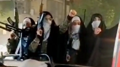 Mujeres iraníes marchan en una protesta con fusiles Kaláshnikov y RPG