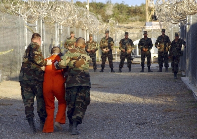 Policía militar de EEUU traslada a un detenido en Camp X-Ray, en la base de Guantánamo, en una imagen de 2002 (Reuters).