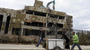 Peatones pasan frente a los restos de la antigua Embajada china en Belgrado, Serbia, el 10 de noviembre de 2010