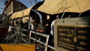 Migrantes mexicanos cruzan el paso fronterizo Paso del Norte tras ser deportados de EE.UU. en medio de la pandemia
