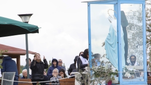 Fieles se congregan frente a la estatua de la Virgen María en la localidad italiana de Trevignano.
