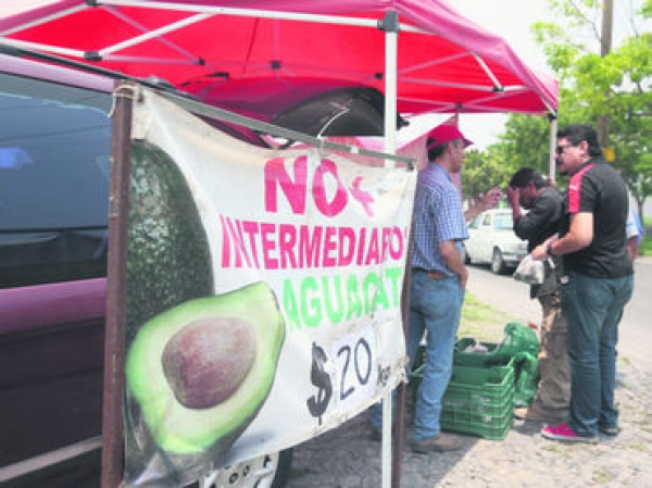 Desde hace un mes, Gerardo Díaz (de gorra) se dedica a la venta de aguacate que ofrece en un puesto ambulante dos veces a la semana.