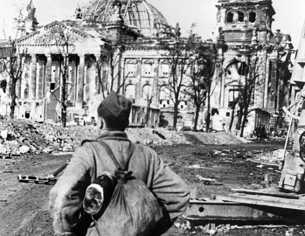 n soldado soviético observa el edificio del Reichstag destruido