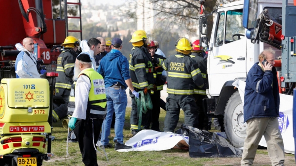 Efectivos de seguridad y rescate en el lugar del incidente, junto al camión que embistió a varios civiles.