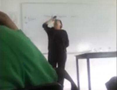 La profesora Teresa Hernández bebe una copa de tequila frente a sus alumnos.