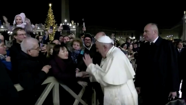 El papa Francisco golpea la mano de una mujer que lo agarró en la Plaza de San Pedro en el Vaticano, 31 de diciembre de 2019.