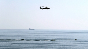 Un helicóptero estadounidense vuela sobre lanchas rápidas iraníes en el estrecho de Ormuz, el 21 de diciembre de 2018. Hamad I Mohammed / Reuters