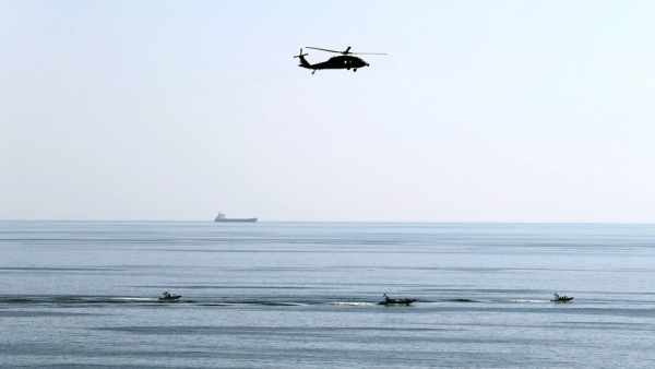 Un helicóptero estadounidense vuela sobre lanchas rápidas iraníes en el estrecho de Ormuz, el 21 de diciembre de 2018. Hamad I Mohammed / Reuters