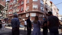 Un grupo de vecinos, ante el bloque de la calle Ram de Viu en el que se cometió el infanticidio