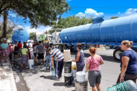 Personal de Servicios de Agua y Drenaje de Monterrey abastece con pipas a habitantes de la colo-nia Revolución, quienes hacen largas filas para recibir el líquido en bidones y botes.