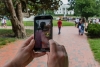 Una mujer sostiene su teléfono celular mientras juega ‘Pokemon Go’ en el parque Lafayette frente a la Casa Blanca en Washington, DC.