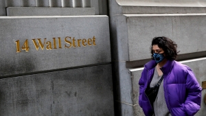 Una persona con máscara camina por Wall Street en Nueva York, el 6 de marzo de 2020.