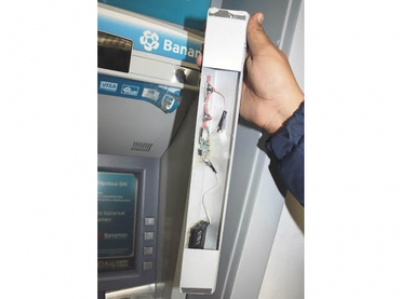 Personal bancario muestra el mecanismo que altera el funcionamiento de los cajeros en lugares concurridos.