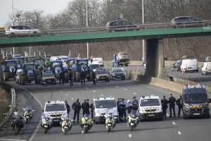 Policías vigilan una manifestación de agricultores en una autopista de en Argenteuil, al norte de París, el 29 de enero de 2024.