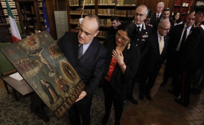 El ministro de Cultura italiano Alberto Bonisoli, a la izquierda, muestra a su homóloga mexicana, Alejandra Frausto, una de las 594 pinturas robadas de México Gregorio Borgia