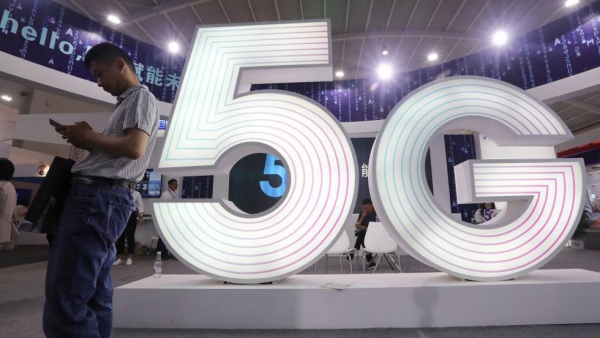 Un hombre maneja un móvil en una feria tecnológica en China. En vídeo, las claves del 5G. 