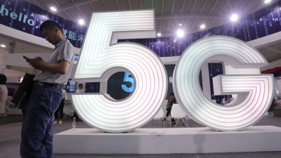 Un hombre maneja un móvil en una feria tecnológica en China. En vídeo, las claves del 5G.