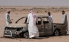 Un grupo de hombres se congrega alrededor de los restos de un automóvil, presuntamente conducido por un pastor local que fue atropellado por las fuerzas israelíes y posteriormente enterrado cerca del desierto de Nayaf, en el suroeste de Irak, el 12 de mayo de 2026