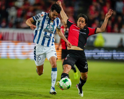 Daniel Aceves, de Pachuca, y José Abella, de Atlas, luchan por el balón durante el partido de vuelta de la final de la liga mexicana de futbol en el estadio Hidalgo.