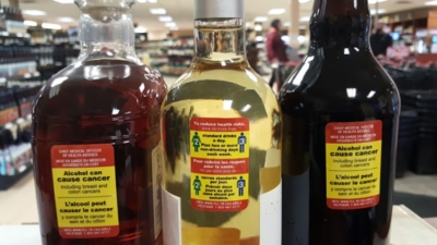 Etiquetas de advertencia sobre los riesgos para la salud asociados con el alcohol en varias botellas en el marco de un programa de prueba de etiquetado en Yukón, Canadá.