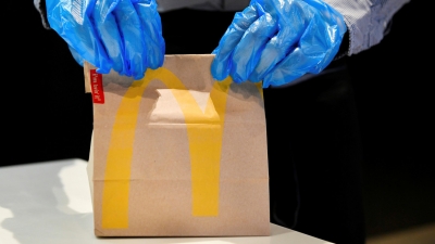 Un empleado con guantes maneja un pedido en un McDonald's en Arnhem, Países Bajos, el 1 de mayo de 2020.