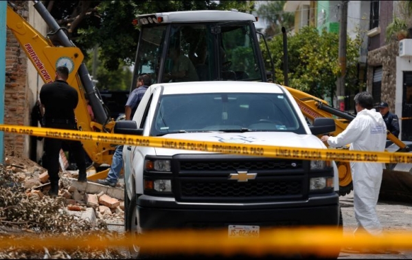 Personal del Semefo realiza excavaciones con maquinaria pesada en el patio de la casa en la colonia Santa Elena de la Cruz. 