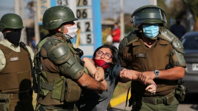 Una mujer es detenida después de gritar consignas contra la policía antidisturbios en un barrio pobre de la comuna El Bosque, en Santiago, Chile 18 de mayo de 2020.