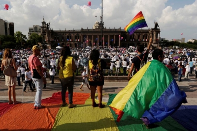 Varios activistas alzan banderas arcoiris en frente de miles de personas que protestan contra el matrimonio homosexual, en Monterrey