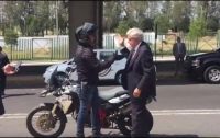 Al descender de la motocicleta, Andrés Manuel agradece al piloto con un saludo de manos.