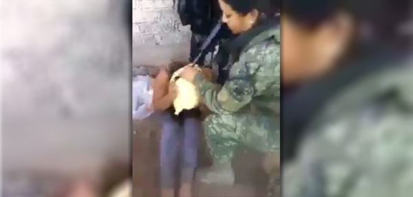 Una soldado coloca una bolsa en la cabeza de su víctima.