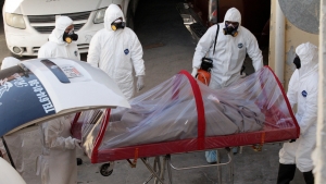 Trabajadores funerarios extraen el cuerpo de una víctima de coronavirus en Ciudad Juárez. 7 de abril de 2020.