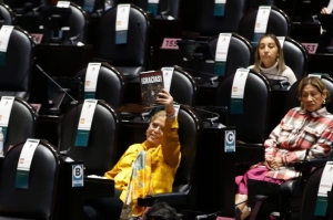 La diputada María de Jesús Páez, del PT, muestra un ejemplar del libro '¡Gracias!', del presidente López Obrador.