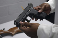 Una pistola de una colección de armas ilegales se revisa durante un evento de recompra de armas en Brooklyn, Nueva York, el 22 de mayo de 2021. 