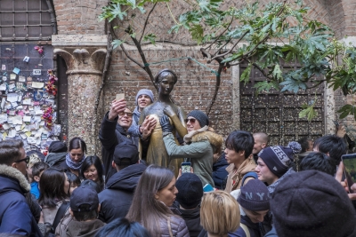 Turistas hacen fotos con la estatua de Julieta, Verona, Italia.